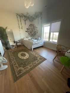 a bedroom with hardwood floors and a rug on the floor next to a bed in front of a window