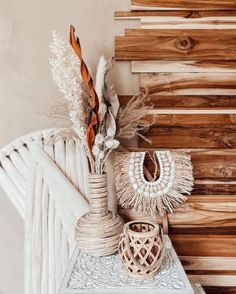 a white table topped with a vase filled with flowers next to a wooden stair case