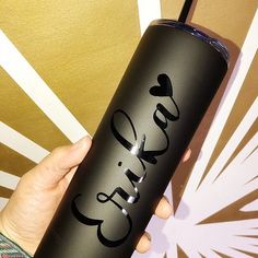 a hand holding a black tumbler with the word girl on it