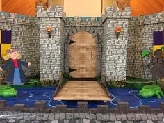 an entrance to a castle decorated with paper cut outs and fake alligators on the ground