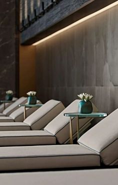 rows of lounge chairs with flower vases on them