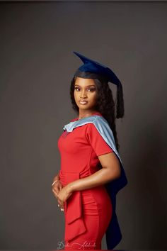 a woman wearing a graduation cap and gown posing for a photo in front of a gray background