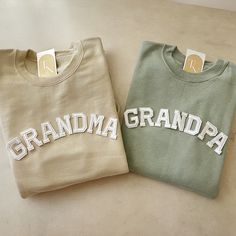 two sweatshirts with the words grandma and grandpa on them sitting next to each other