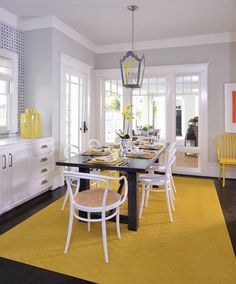 a dining room with yellow and white chairs