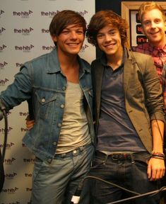 two young men standing next to each other in front of a microphone and recording equipment