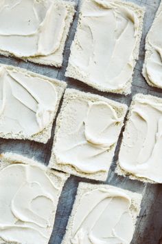 several squares of white frosted food on a table