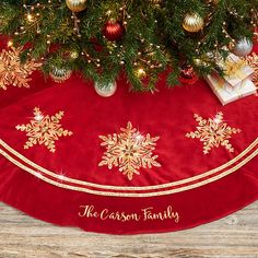 a red christmas tree skirt with gold snowflakes on it and the words, the cassson family