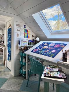 a room with a skylight and various items on the table in front of it