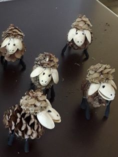 four sheep made out of pine cones on a table