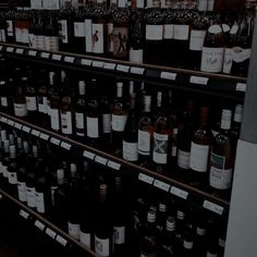 many bottles of wine are on shelves in a store