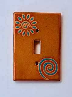 a decorative light switch cover with blue and orange designs