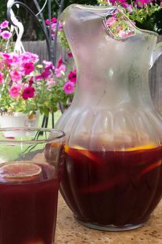 a pitcher of liquid sitting next to a glass filled with liquid