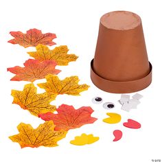 a paper hat and fall leaves on a white background with other items to make it look like they have fallen apart