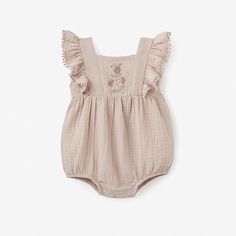 Good for baby, good for the environment. Our organic, naturally sustainable muslin is soft and breathable, ideal for outdoor adventures during the spring and summertime. Cast in a dreamy palette, this muslin baby romper combines fashion and function for the modern child. Floral embroidery and pom-lace adds an extra dash of style and luxury to this already stunning muslin baby romper. 100% organic cotton muslin, GOTS certified Features snap crotch for easy changing Button closure on back Flutter Beige Cotton Onesie For Spring, Cream Bubble Romper For Beach In Summer, Cream Bubble Romper For Beach And Summer, Beige Bubble Romper With Ruffles For Summer, Beige Cotton Bubble Romper For Summer, Cream Onesie For Summer Playtime, Summer Cream Onesie For Playtime, Beige Bubble Romper For Summer Playtime, Beige Ruffled Bubble Romper For Summer