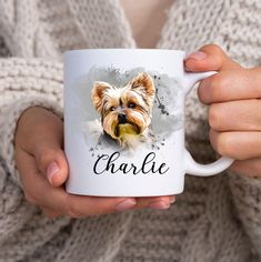 a person holding a coffee mug with a dog on it