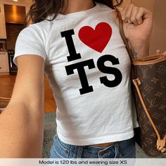 "I Love TS I Heart TS" Graphic Slogan Printed On Aesthetic Retro Vintage 90s Y2k Baby Tee Shirt with our own unique font.  🎨 Available in White, Light Pink, Light Blue, Navy, Black. If you need a different color, please let us know! (Ash, Red, Sport Grey & Green)  🎁 Our baby tees are perfect gift for her or him offering timeless fashion and versatility that anyone will cherish. Baby tees, popular in the '90s, have short sleeves and a slightly cropped body, giving a flattering feminine shape. T Baby Tee Shirt, Y2k Graphic Tees, Aesthetic Baby, Unique Font, Baby Tee Shirts, Aesthetic Retro, Streetwear Mode, Baby Tees Y2k, Retro Baby