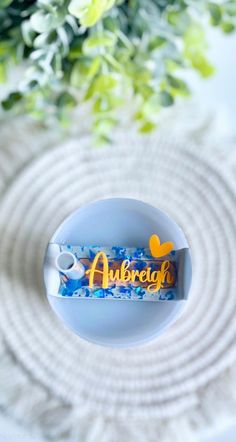 a tube of toothpaste sitting on top of a white table next to flowers