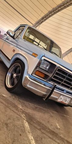 an older pickup truck parked in a garage