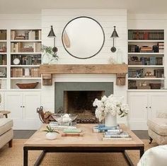 a living room filled with furniture and a fire place in front of a book shelf