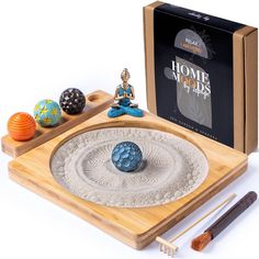 the incense bowl is next to an assortment of decorative items on a wooden platter