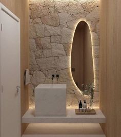 a bathroom with stone walls and lights on the wall, along with a white sink