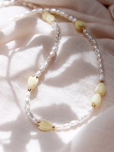 "Inspired by traditional Hawaiian leis gifted as tokens of hospitality, this handmade gold and pearl necklace features a glistening collection of pearls, gold beads and pikake flower blossoms. ✦ DETAILS ✦ ✧ Name: Mele (MEH-leh) - Song. ✧ Adjustable Length from: 16\"-18\". ✧ White Freshwater Pearls. ✧ Carved Resin Pikake Beads ✧ 14kt Gold Filled Components, Extender, and Clasp. ✧ All Ke Aloha Jewelry pieces come packaged thoughtfully, beautifully, and ready for gift giving. ✦ MORE GOLD NECKLACES Yellow Pearl Necklaces With Round Beads, Handmade Yellow Pearl Necklaces, Yellow Beaded Pearl Necklace, Yellow Pearl Beaded Necklaces As Gift, Yellow Beaded Pearl Necklace As Gift, Yellow Beaded Pearl Necklace Gift, Handmade Yellow Pearl Necklace For Gift, Pearl Necklace With Gold Beads For Gift, Yellow Pearl Necklace As Gift