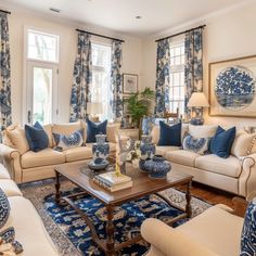 a living room with blue and white decor on the walls, couches, coffee table and rugs