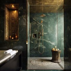 an elegant bathroom with green marble walls and floor, along with a walk in shower