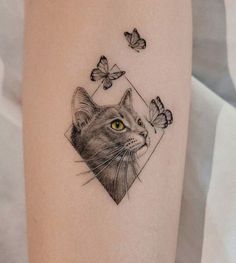 a cat and butterflies tattoo on the right thigh, it is black and white with yellow eyes