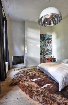 a bedroom with a large bed and an animal skin rug on the floor in front of it