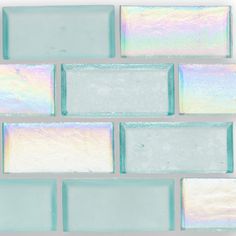 the back side of a glass tile wall with pastel blue and silver tiles on it