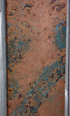 an old rusted metal door with blue paint on it's sides and bottom