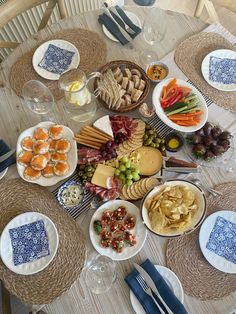 the table is set with many different types of food and wine glasses on top of it