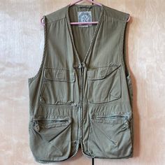 Vintage Br From The Late 80’s. Multi Function Vest With Four Large Front With Either Velcro Closure Or Zip Pockets, Two Inside And One Large Zip Pocket On The Back Interior As Shown Also Has A Belt Tab In The Back As Shown In The Photo. Front Zip And Also Has Three Button Tabs Deep Khaki Green Color Most Like The Last Photo. Closeup Pix Are Lighter Than Actual. 100% Cotton Excellent Condition. Size Med. Safari Vest, Vintage Safari, Khaki Green, Green Color, Green Colors, Banana Republic, Zip Pockets, Mens Jackets, Jackets & Coats