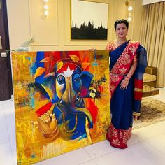 a woman standing in front of a painting with an elephant on it's face