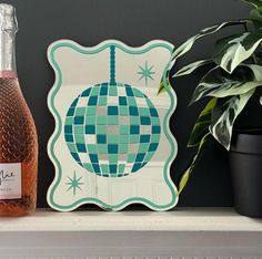 a bottle of wine sitting on top of a shelf next to a potted plant