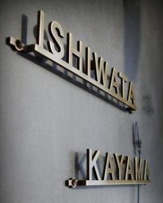 two metal name plates mounted to the side of a wall