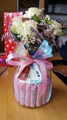 a vase filled with candy and flowers on top of a table