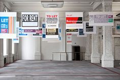 an empty room with several signs hanging from the ceiling