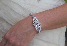 "Stunning and elegant crystal bridal bracelet! Chantelle is a truly glamorous accessory that will shimmer and sparkle with every move of your hand. How gorgeous will this look as you walk down the aisle, bouquet in hand and on the arm of your gorgeous man? We have used high quality marquise CZ crystals which are the closest match to real diamonds, in a petal burst design with a dreamy Ivory white Swarovski pearl as the centrepiece. Customize your pearl color! Crystals wrap your wrist and we have White Sparkling Diamond Bracelet For Wedding, Sparkling Diamond Wedding Bracelet, White Crystal Diamond Bracelet For Wedding, Wedding Crystal Diamond Bracelet With Sparkling Stones, Wedding Diamond Bracelet With Crystals, Dazzling Diamond Bracelet With Sparkling Stones For Wedding, Silver Diamond Bracelet With Sparkling Stones For Wedding, Dazzling Bracelet With Sparkling Stones For Wedding, Dazzling Bracelets With Sparkling Stones For Wedding