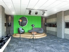 the room is set up for an event with green walls and grey carpeting, while two black chairs sit in front of them