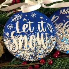 two christmas ornaments with let it snow written on them