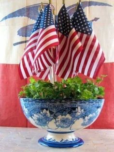 an american flag hanging over a potted plant