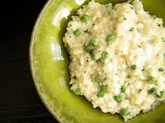 a green bowl filled with mashed potatoes and peas