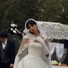 a woman in a wedding dress standing next to a man