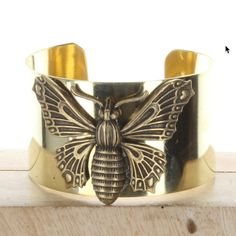 "butterfly cuff bracelet , 1.5\" wide, antique gold, Made in USA, Each" Gold Cuff Bracelet With Antique Finish, Antique Gold Metal Cuff Bracelet As Gift, Antique Gold Metal Cuff Bracelet For Gift, Gold Cuff Bracelet With Antique Finish As Gift, Gold Antique Finish Cuff Bracelet, Gold Antique Finish Cuff Bangle, Gold Antique Finish Bangle Cuff Bracelet, Antique Brass Cuff Bracelet Gift, Vintage Antique Gold Brass Cuff Bracelet