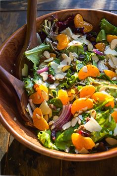 a salad in a wooden bowl on top of a table