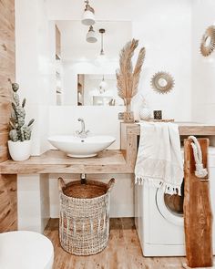 a washer and dryer sitting in a bathroom next to each other on a wooden floor