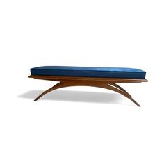 a wooden bench with a blue cushion on it