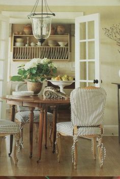 a dining room table with chairs and a potted plant on top of the table